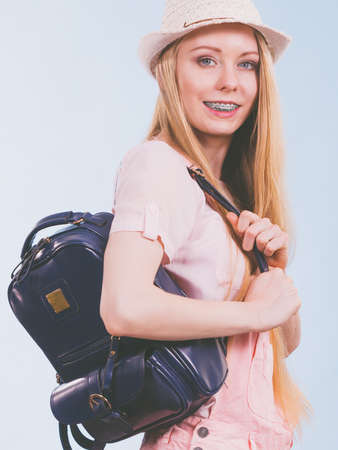 Happy young blonde teenage girl going to school or college wearing backpack.の写真素材
