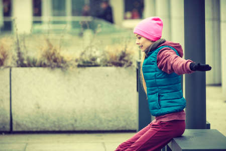 Outdoor sport exercises, sporty outfit ideas. Woman wearing warm sportswear training exercising, stretching legs outside during autumn.の写真素材