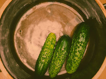 Preparing sour low salt cucumbers in clay jar pot. View from aboveの写真素材