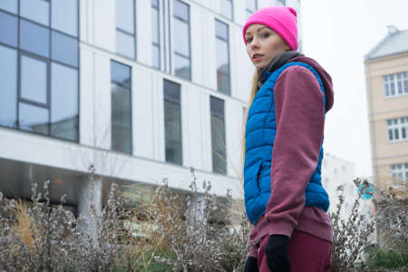 Outdoor sport exercises, sporty outfit ideas. Woman wearing warm sportswear training exercising...