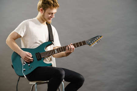 Man playing on electric guitar during gig. Musical instrument. Teenage boy having music hobby.の写真素材