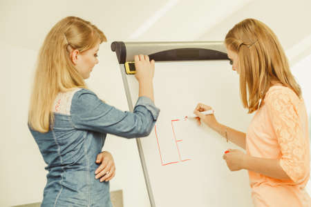 Education, knowledge, wisdom and learn new things concept - student girls writing Learning word on whiteboardの写真素材