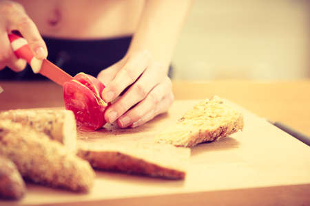 Woman preparing healthy breakfast making delicious sandwich in kitchen. Good dieting concept.の写真素材