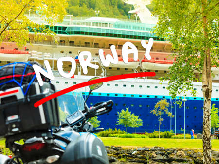 Tourism vacation and travel. Closeup motorcycle and big cruise ship in Flam Norway Scandinavia.の写真素材