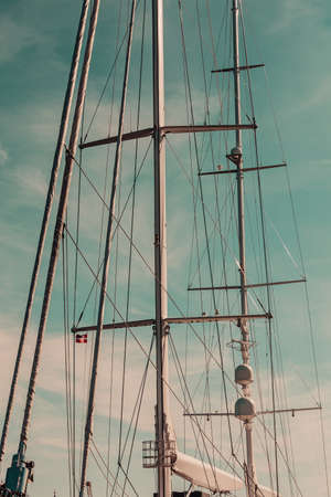 Detailed closeup of mast rigging top on sail boat during cruise, shot on blue sky. Marine objects concept.の写真素材