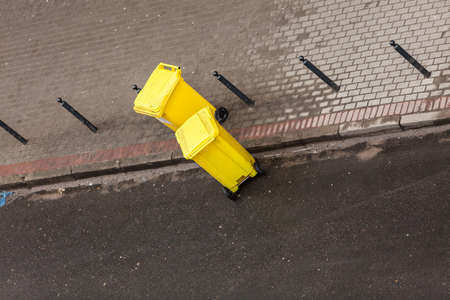 Plastic yellow wheely bins in the street outside waiting for garbage truck. Top viewの写真素材
