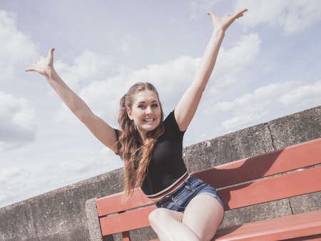 Happy joyful smiling woman spending her free time outside enjoying beautiful summertime weather.の写真素材
