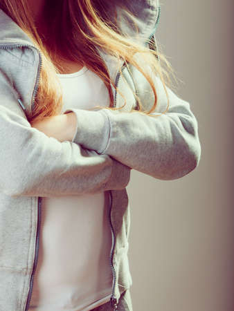 Closeup of rebellious teenager crossing arms wearing sweatshirt.の写真素材