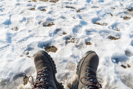 Somebody legs with warm winter shoes on snow. Footwear for cold daysの写真素材