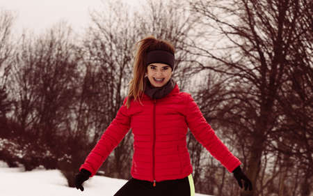 Outdoor sport exercises, sporty outfit ideas. Woman wearing warm sportswear training exercising outside during winter.の写真素材
