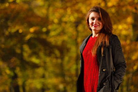 Girl taking walk through park. Young female, walking through forest in autumn. Nature relax outdoors concept. の写真素材