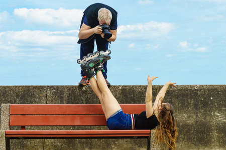 Man photographer taking crazy picture of fashion sporty women model wearing roller skates.の写真素材