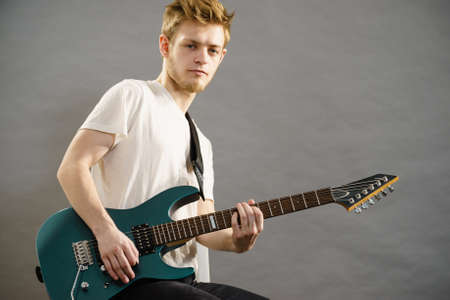 Man playing on electric guitar during gig. Musical instrument. Teenage boy having music hobby.の写真素材