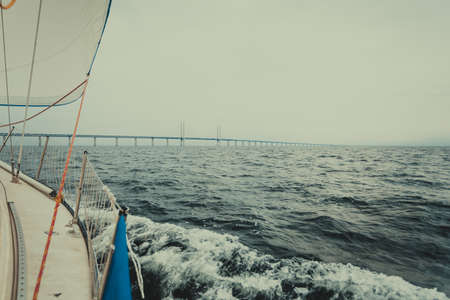 Oresundsbron. The Oresund bridge link between Denmark and Sweden, Europe, Baltic Sea. View from sailboat yacht. Overcast sky. Landmark and travel.の写真素材