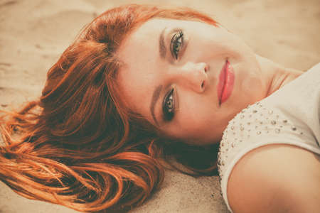 Holidays, vacation travel and freedom concept. Attractive red haired girl on beach. Young pretty...