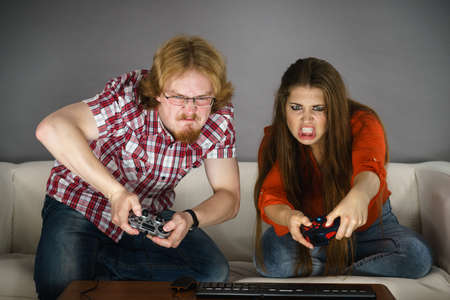 Addicted couple playing video games together being very emotional. Studio shotの写真素材