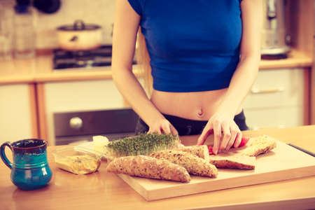 Woman preparing healthy breakfast making delicious sandwich in kitchen. Good dieting concept.の写真素材