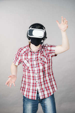 Man playing video game wearing virtual reality device. Gaming equipment for gamers concept.の写真素材