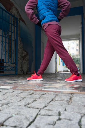 Sport and recreation. Fit slim sporty teen girl stretching warming up outdoor on city street. Woman exercising on fresh air.の写真素材