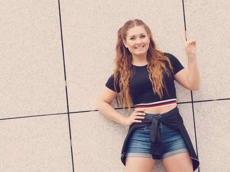Young teenage woman wearing denim shorts and black crop top. Female presenting fashionable summer...