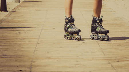 Woman slim legs wearing roller skates standing outside. Sport activity objects concept.の写真素材