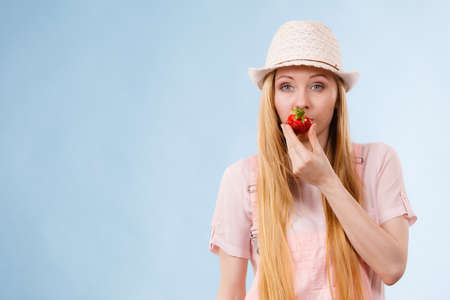 Happy cheerful teenage young woman ready for summer wearing pink outfit and sun hat holding sweet...