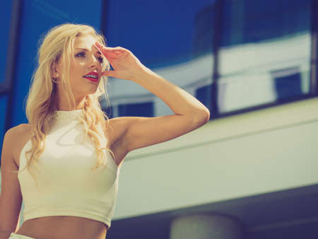 Elegant fashionable fashion female model. Woman in city waiting for someone looking in distance.の写真素材