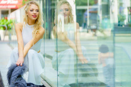 Glamorous female fashion model presenting casual elegant outfit. Woman wearing crop top and skirt. Summer urban outfit, outdoor photo session.の写真素材