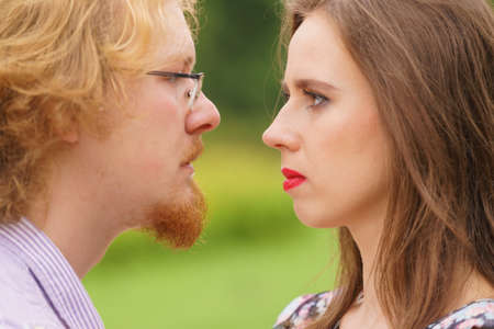 Serious man and woman looking into each other eyes having bad argue fight. Confident people, relations problems concept.の写真素材