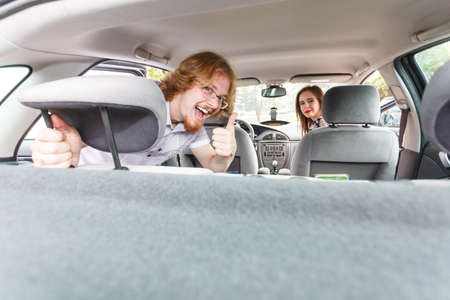 Happy man and woman couple sitting in car enjoying their travel trip inside vehicle.
