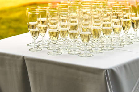 Many glasses of champagne on white table. Outdoor shot during wedding partyの写真素材