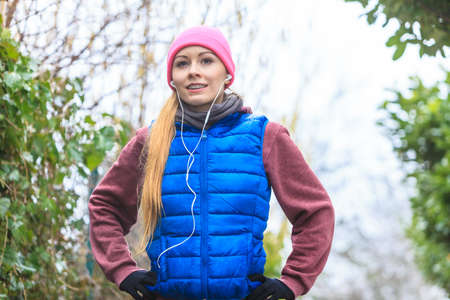 Outdoor sport exercises, sporty outfit ideas. Woman wearing warm sportswear training exercising outside during autumn, warming up before workout.の写真素材