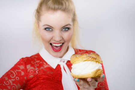 Woman holding sweet cupcake cake dessert with cream, she wants to eat it.の写真素材