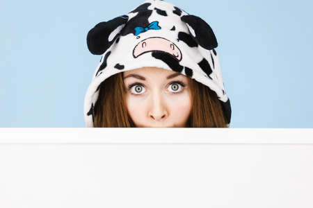 Positive teenage girl in funny nightclothes, pajamas cartoon style with blank empty banner board. Advertisement copyspace.の写真素材