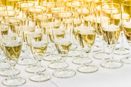 Many glasses of champagne on white table. Outdoor shot during wedding partyの写真素材