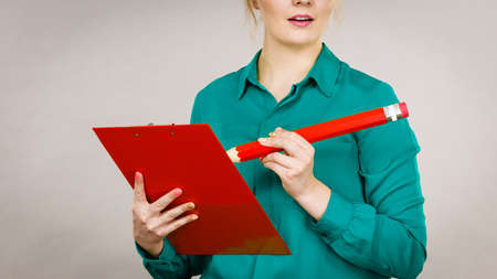 Young business woman wearing jacket intensive thinking finding great problem solution and ideas writing something down in note.の写真素材