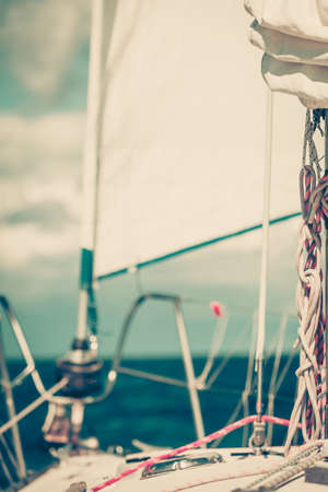 Yachting on sail boat during sunny summer weather on calm blue sea water. Sporty transportation conept.の写真素材