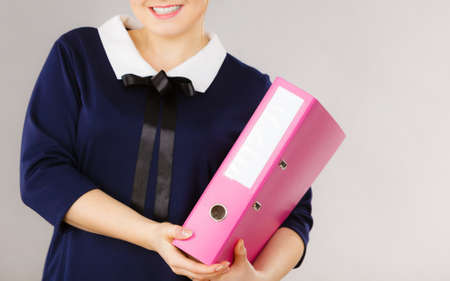 Happy positive accountant business woman holding binder with documents, enjoying her work.の写真素材