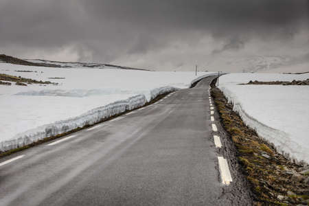 Snowfield and mountain road Aurlandsvegen between Aurland and Laerdal in Norway, summer timeの写真素材