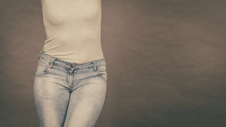 Woman wearing tight slim jeans and white tshirt, showing her great body curves. Well-fitting pants