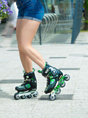 Woman slim legs wearing roller skates standing outside. Sport activity objects concept.の写真素材