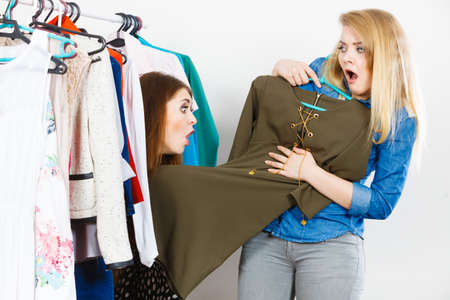 Two young women during shopping time picking perfect casual short dress for friend.の写真素材