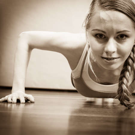 Woman training, working out at home doing push ups, being fit and healthy. Close up shot