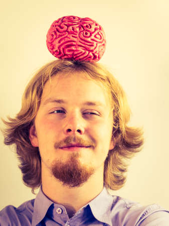 Funny nerd man having human brain model on head. Education and knowledge symbolの写真素材