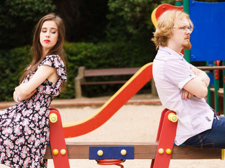 Offended upset couple young male and female not talking to each other sitting back to back after argument quarrel. Disagreement in relationship.の写真素材