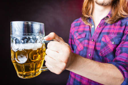 Drinking alcohol liquor relax concept. Young man drinking pint. Male in shirt holding stein with beer. の写真素材