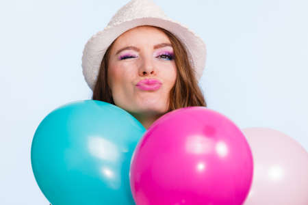 Woman charming girl playing with many colorful balloons. Summer, celebration happiness and lifestyle concept. Studio shot blue backgroundの写真素材