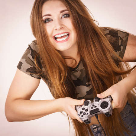 Young adult woman playing on the video console holding game pad. Gaming gamers concept.