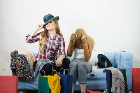 Two happy joyful women having fun after shopping, picking outfit in closet. Female friends fooling around.の写真素材