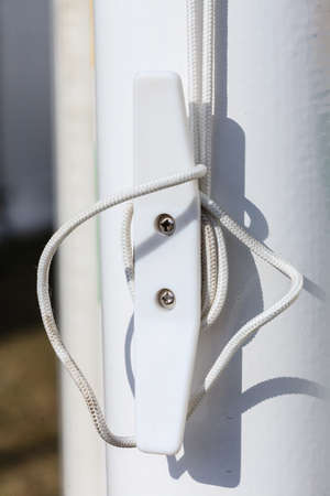 Sailing equipment, textile concept. Detailed closeup of rope on white plastic rook